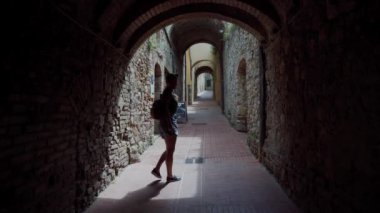 San Gimignano, İtalya - 17 Mayıs 2019: Kadın kale tünelinde yürüyor