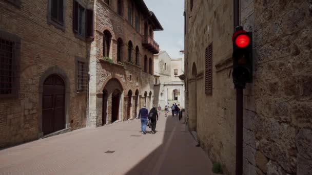 サン・ジミニャーノ,イタリア- 2019年5月17日:家の壁にセットされた交通信号を持つ通り — ストック動画