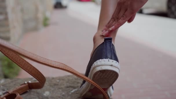 Жінка подряпала ногу у відпустці. Дівчина в туфлі мазе цілющий крем на нозі — стокове відео
