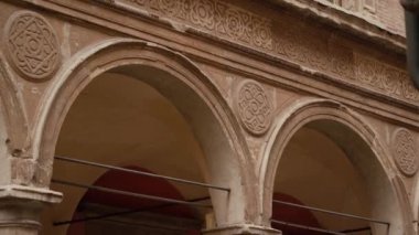 Taş sütunlar, kemerler, dekoratif sıva elemanları ve pencerelerle ön cephe