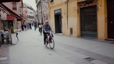 Ferrara, İtalya - 20 Mayıs 2019: Eski şehir sokağı, mimari, insanlar, dükkan, bisiklet