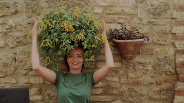 Schöne Frau verwendet grüne Blume statt Haare. Ungewöhnlich lustiges Frühjahrsporträt — Stockvideo