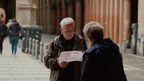 Bologna, Italien - 20. Mai 2019: Ältere Menschen schauen auf Landkarte, diskutieren Richtung — Stockvideo