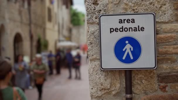 Pedestrian zone road sign, Italian text area pedonale. Blurry alley, tourists — Stock Video