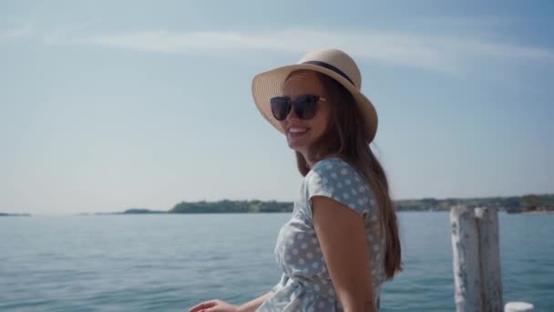 Hermosa chica en gafas de sol se quita el sombrero de paja y cubre la cámara con su — Vídeos de Stock