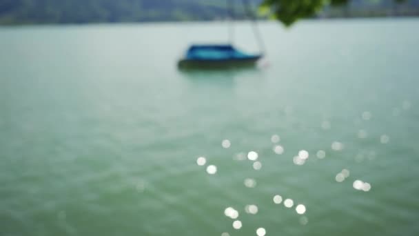 Kikötött hajó a Tegernsee tónál a napsütéses napon. Homályos vízfelület napfénnyel — Stock videók