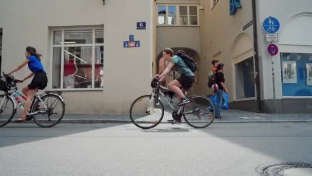 РЕГЕНСБУРГ, ГЕРМАНИЯ - 25 мая 2019 года: Велогонщики едут по улице мимо камеры, арки — стоковое видео