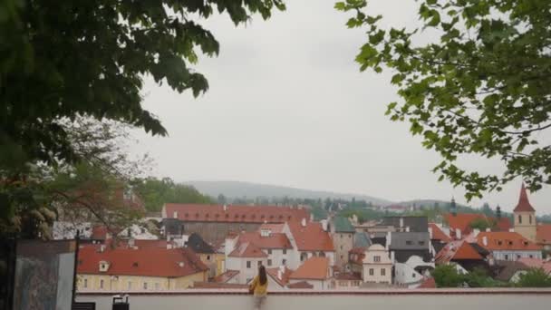 Άποψη της μυθικής πόλης του Cesky Krumlov. κορίτσι κοιτάζει σπίτια κόκκινο κεραμίδι στέγες — Αρχείο Βίντεο