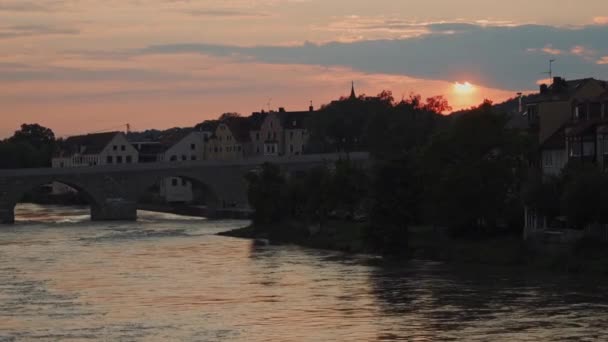 Malowniczy różowy zachód słońca na niebie nad typową architekturą Ratyzbony, rzeki, mostu — Wideo stockowe