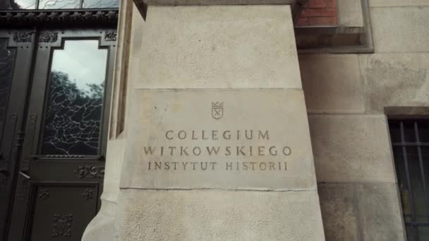 KRAKOW, POLÓNIA - 30 de maio de 2019: placa de identificação no edifício The Collegium Witkowski — Vídeo de Stock