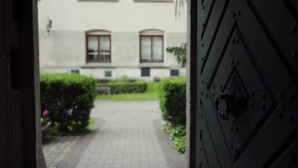 Hermosa puerta abierta a través del cual se puede ver el patio con jardín verde — Vídeo de stock