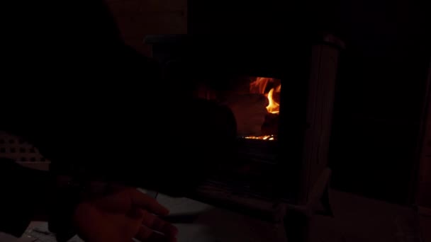 Mann legt Kiefernbrennholz in den Kamin Brennendes Feuer im Kamin. — Stockvideo