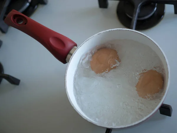 Huevos cocidos en una olla de agua caliente — Foto de Stock