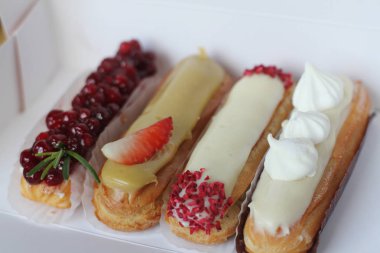 Geleneksel Fransız tatlısı. Krema ve çilek ile güzel eclairs.