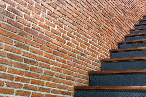 Стены из красного кирпича на фоне железной лестницы — стоковое фото
