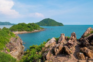 Dağ tepe boyunca mavi deniz ve gökyüzü karşı yüksek kayaların üzerinden görüntüleyin. Renkli dağ manzarası. Deniz kıyısı tatilde. Yaz seyahat Tayland.