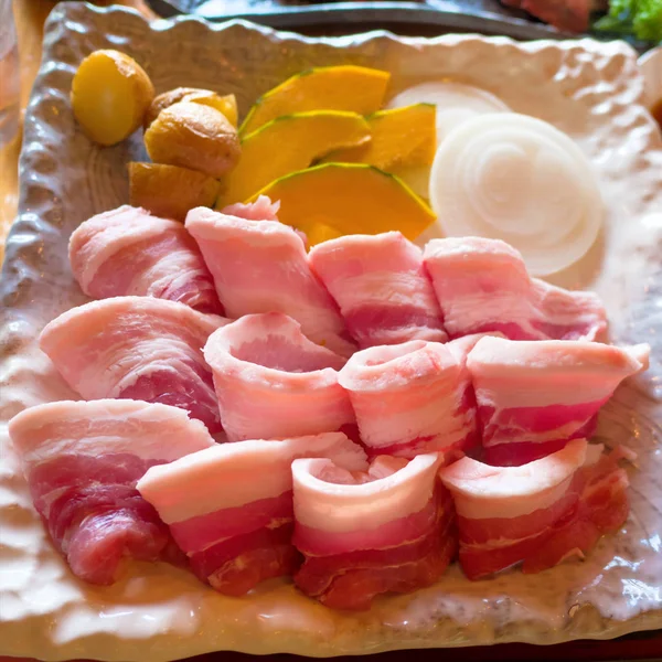 Tocino rayas de cerdo y verduras en el plato en la barbacoa, yakiniku parrilla restaurante buffet —  Fotos de Stock