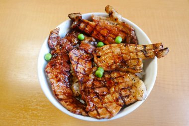 Üstten Görünüm Butadon kase dilimlenmiş domuz eti ve tatlı sauceon ahşap arka plan ile tepesinde pirinç. 