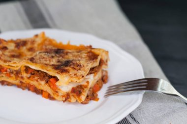 Sığır eti bolognese soslu beyaz tabakta yapılan geleneksel lazanya Close-Up