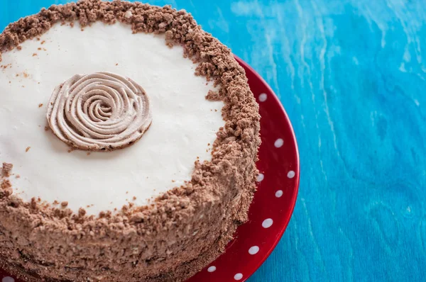 Chocolate cake with whipped cream on the red plate Royalty Free Stock Photos