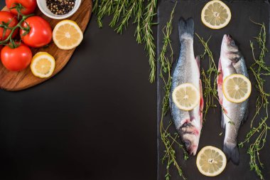 taze levrek, biberiye, domates, limon, biber ve baharat masada