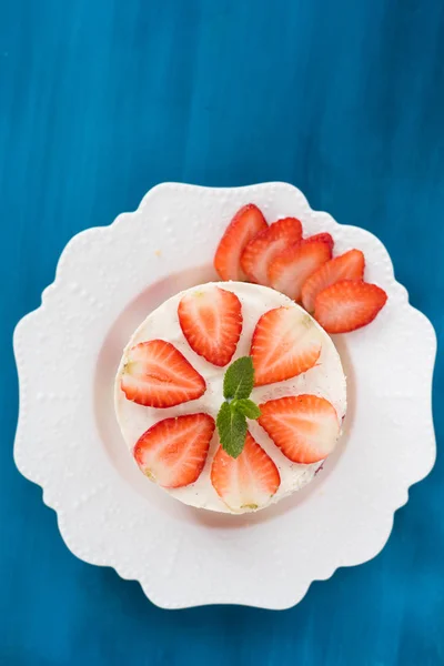 Summer strawberry mousse cake with fresh berries on the wooden blue background top view