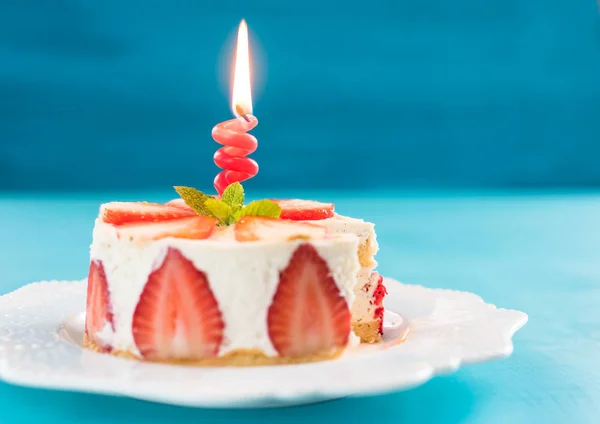 Strawberry cake with vanilla cream with a candle, happy birthday concept