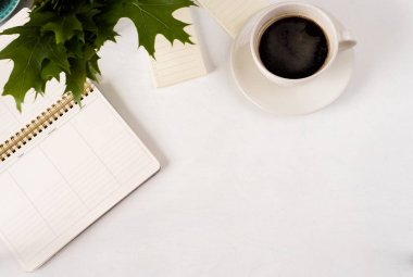 Beyaz tasarımcı ofis Resepsiyon Masaları boş defter sayfası fincan kahve ile birlikte. Üstten Görünüm, düz yatıyordu.