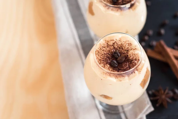 Crema de postre tiramisú en un vaso de coñac decorado con granos de café vista superior — Foto de Stock