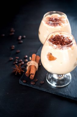 tiramisu bir bardak kahve çekirdekleri karanlık bir arka plan, metin için yer ile dekore edilmiş