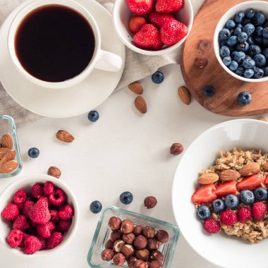 Günaydın - yulaf ezmesi kahve, çilek, yumurta, fındık ile sağlıklı kahvaltı arka plan. Beyaz ahşap gıda arka plan, üstten görünüm