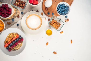 Günaydın - yulaf ezmesi kahve, çilek, yumurta, fındık ile sağlıklı kahvaltı arka plan. Beyaz ahşap gıda arka plan, üstten görünüm