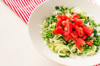 Gürcü salata domates salatalık, soğan, çizgili beyaz masa kırmızı peçete üzerinde