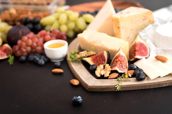 peynir, bal, incir, fındık, üzüm ve meyve bir tabloda farklı türde. Seçici odak. Kopya alanı.