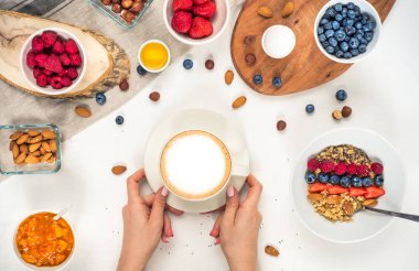 Günaydın - yulaf ezmesi kahve, çilek, yumurta, fındık ile sağlıklı kahvaltı arka plan. Kahve, eller, tutun, cup. Beyaz ahşap gıda arka plan, üstten görünüm