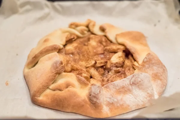 Hausgemachter Apfelkuchen auf Pergamentpapier nur aus dem Ofen — Stockfoto