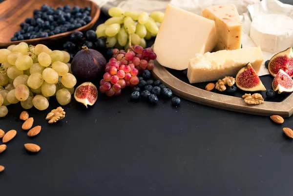 Provsmakning ostkupa med frukter, bär på gamla svart ostbricka. Mat för vin och romantiska, ost delikatesser. Ovanifrån. utrymme för text — Stockfoto