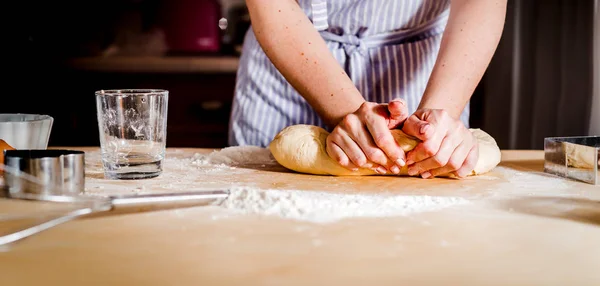 Mãos das mulheres amassar a massa na mesa, acessórios de cozinha — Fotografia de Stock