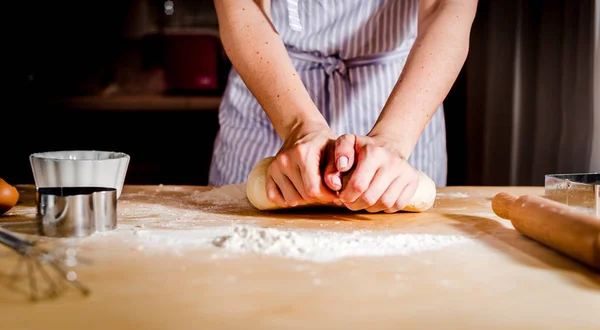 Les mains des femmes pétrissent la pâte sur la table , — Photo