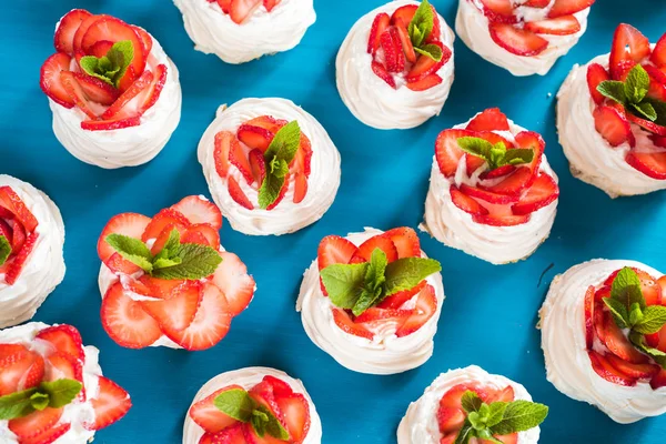 Homemade small strawberry pavlova meringue cakes pattern with cream top view — Stock Photo, Image