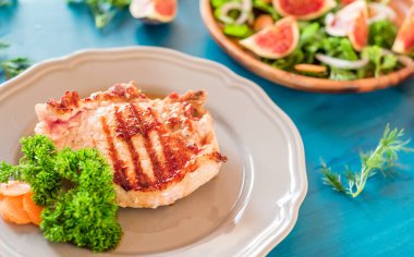 Gri plaka mavi arka plan üzerinde ızgara biftek