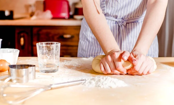 Les mains des femmes pétrissent la pâte sur une table — Photo