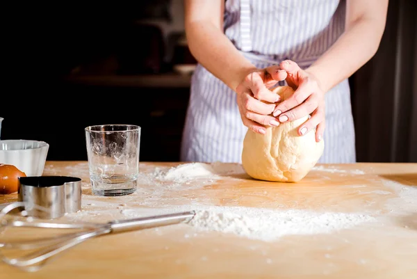 Facendo la pasta da mani femminili su tavolo di legno — Foto Stock