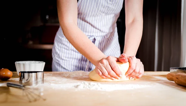 Facendo la pasta da mani femminili su tavolo di legno — Foto Stock