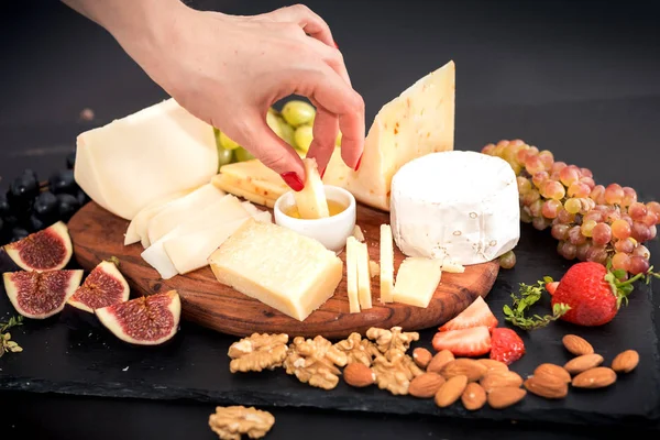 Olika sorters ostar, honung, fikon, nötter, druvor och frukt på ett bord. Selektivt fokus. Kopiera utrymme. — Stockfoto