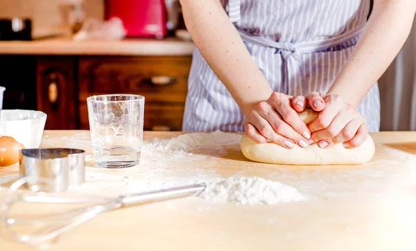 Le mani della donna impastano la pasta su un tavolo, per la vacanza — Foto Stock