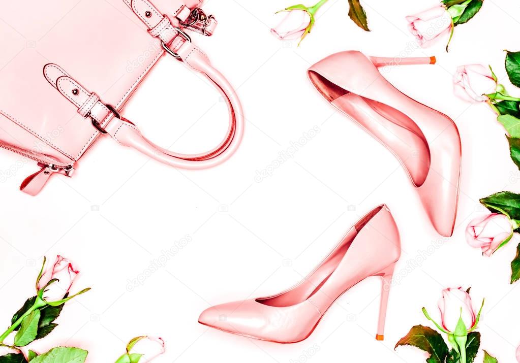 Pastel pink women high heel shoes and bag on pink background. Flat lay, top view trendy fashion feminine background. Beauty blog concept. Fashion blog look.