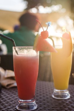 Ev sülün mavi taş arka plan üzerinde karpuz, çilek, muz ve bütün çam elma dilimleri ile dekore karpuz ve ananas güler yüzlü yaptı. Sağlıklı içecekler ve gıda kavramı