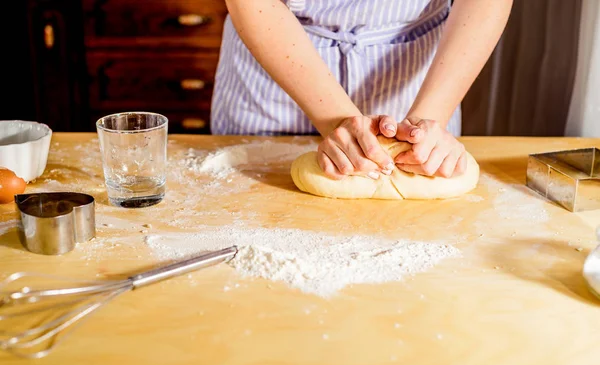 Facendo la pasta da mani femminili su tavolo di legno — Foto Stock