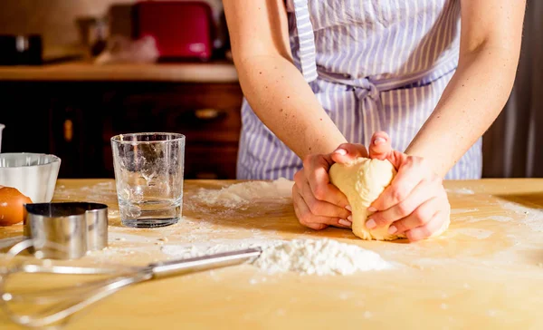 Le mani di donna impastano la pasta su un tavolo — Foto Stock